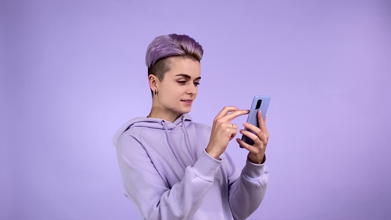 Young woman in purple scrolling text, social media, browsing Internet