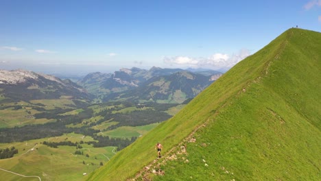 aerial shot circling around counter-clockwise a young white male running alone by himself on a ridge at interlaken, switzerland