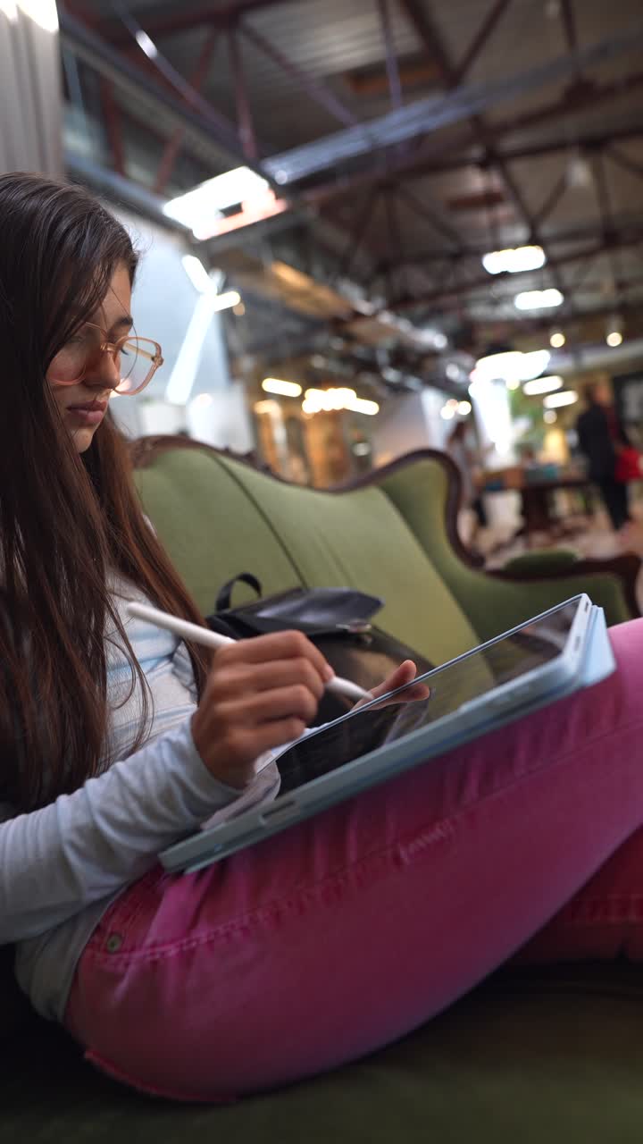 adolescente dibujando en una tableta en un café