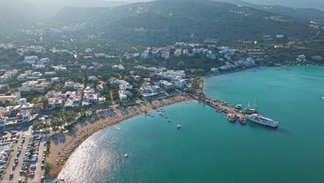 high angle view of the sandy beach, turquoise bay, and boats in elounda, crete