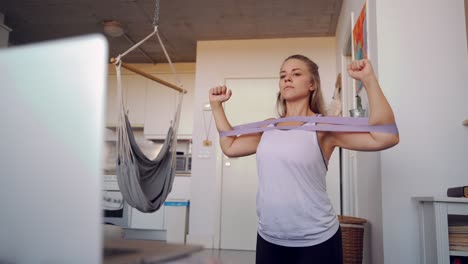 mujer deportista haciendo ejercicio con banda elástica en casa