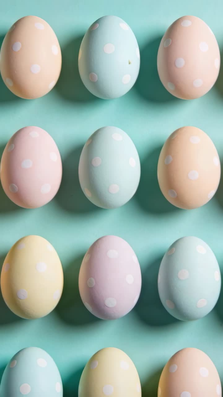 Vertical video: Pulling back camera revealing pastel dotted eggs on mint tabletop showing full grid