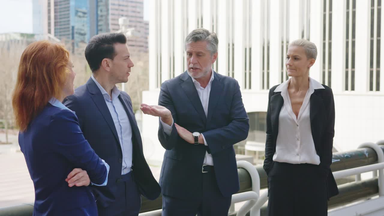 Business professionals having a discussion outdoors in a city setting
