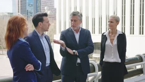 business professionals having a discussion outdoors in a city setting