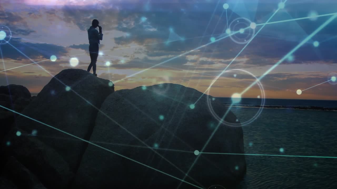 Una donna in piedi sulla riva prende e tocca lo smartphone, attivando un'interfaccia tecnologica che svanisce.
