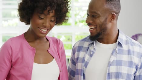 happy man and woman preparing juice in juicer