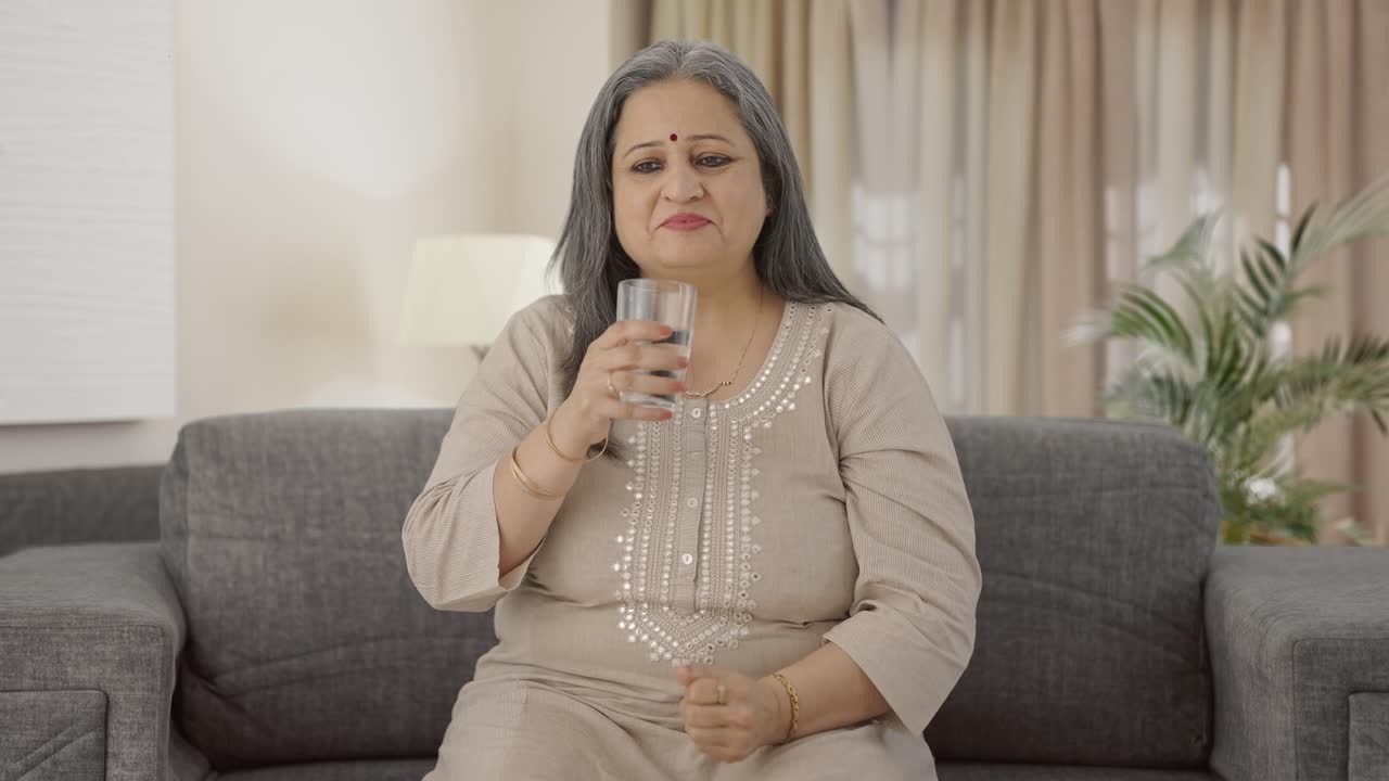 una anciana india feliz tomando medicina