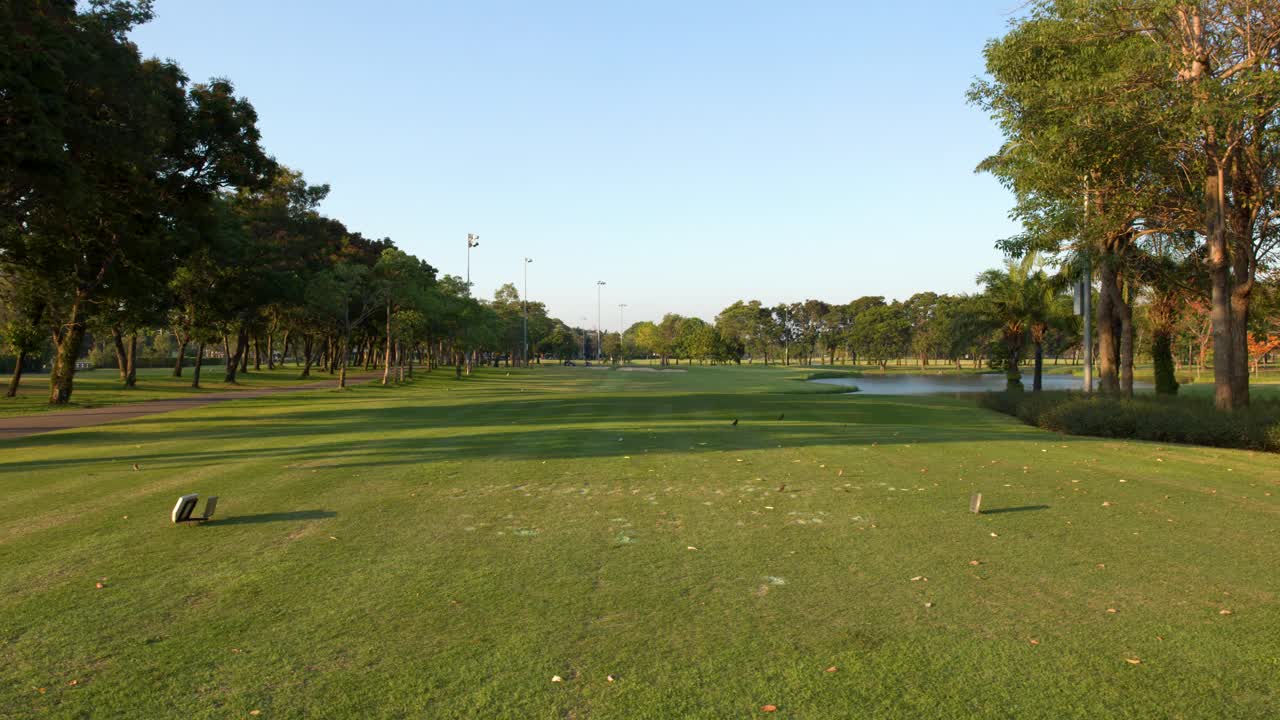 Scenic Golf Course with Green Fairway, Trees, and Water Hazard