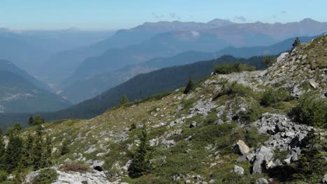 Verdant-valleys-and-blue-lake-in-background,-French-Alps-during-summer-season,-Col-de-la-Loze-in-France