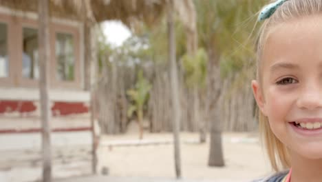 retrato de una chica caucásica feliz mirando a la cámara sobre la casa de la playa.