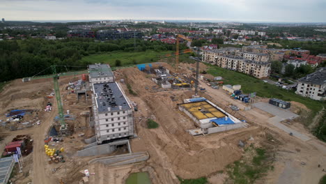 toma aérea hacia atrás del sitio de construcción con grúas en la ciudad de gdansk durante el día nublado, polonia