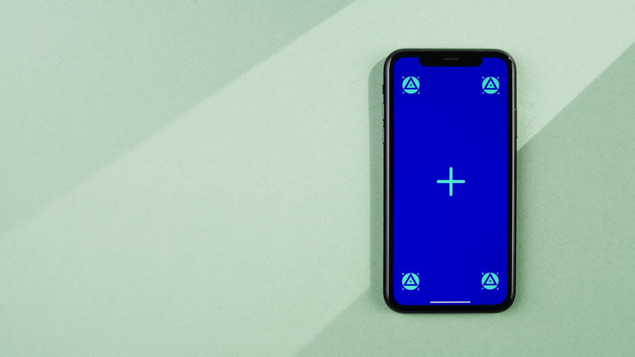 Phone with green screen chroma key on orange background close up, top view. Summer bright texture studio shot for travel business, delivery, food, cosmetology, application.