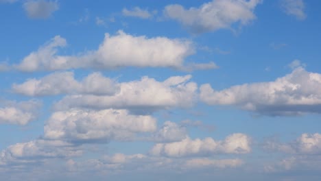 white fluffy clouds drift across a clear blue sky, evoking peace and tranquility