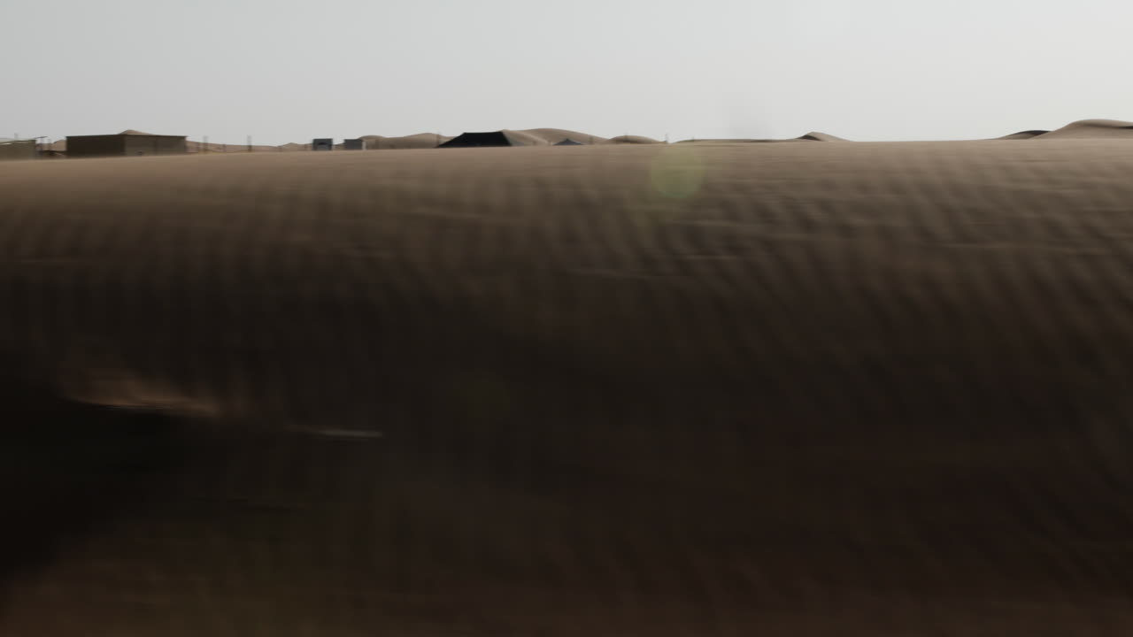 해가 지는 동안 아랍에미리트 두바이 근처의 도로에서 중동의 사막 풍경을 가로질러 운전