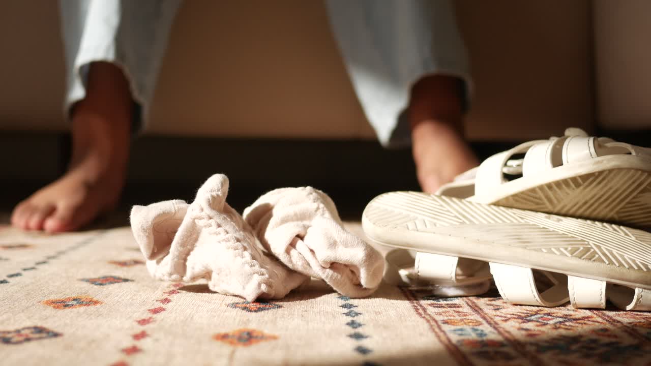 Barefoot, socks and sandals on the floor.