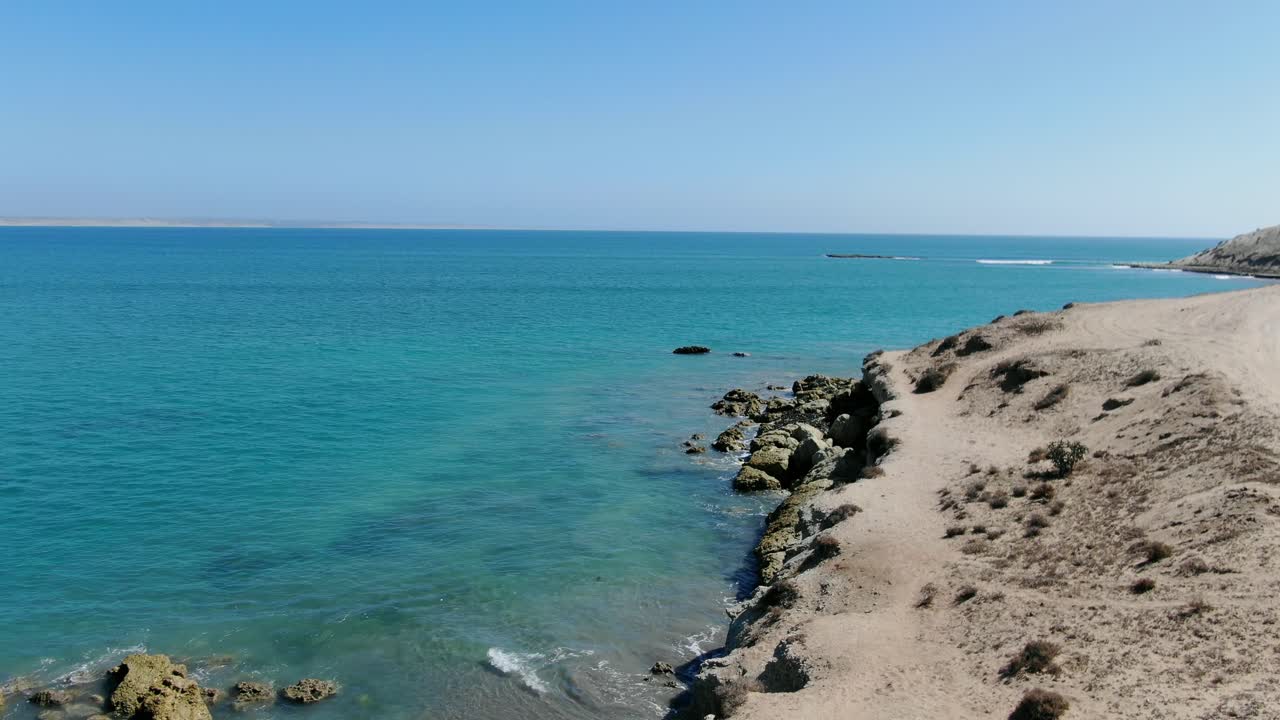 Aerial view Ascending shot, Scenic view of the shoreline of San Juanico Beach in a bright sunny day in California Sur, Mexico, blue sea in the background