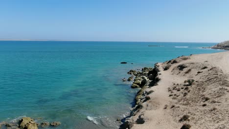 aerial view ascending shot, scenic view of the shoreline of san juanico beach in a bright sunny day in california sur, mexico, blue sea in the background