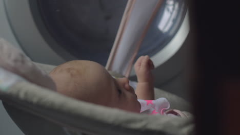 una niña de dos meses en un asiento inflable en casa