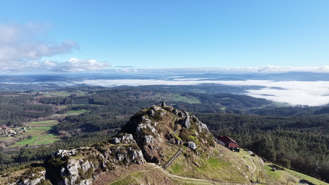 4K Drone shot of Pico Sacro peak near Santiago de Compostela. Panoramic views of the Ulla River valley, green Galician landscape, and the legendary "Calle de la Reina" rock formation under a clear sky