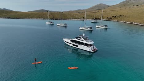 tourists on sup boards and boats in the kornati island bay aerial