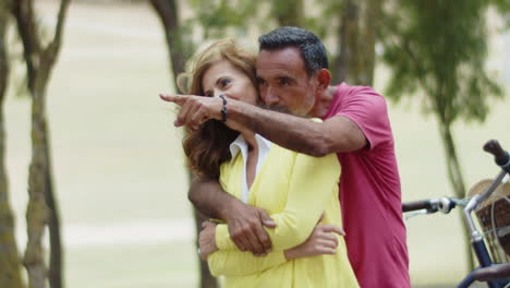 Medium-shot-of-bearded-man-hugging-and-kissing-his-wife-in-park