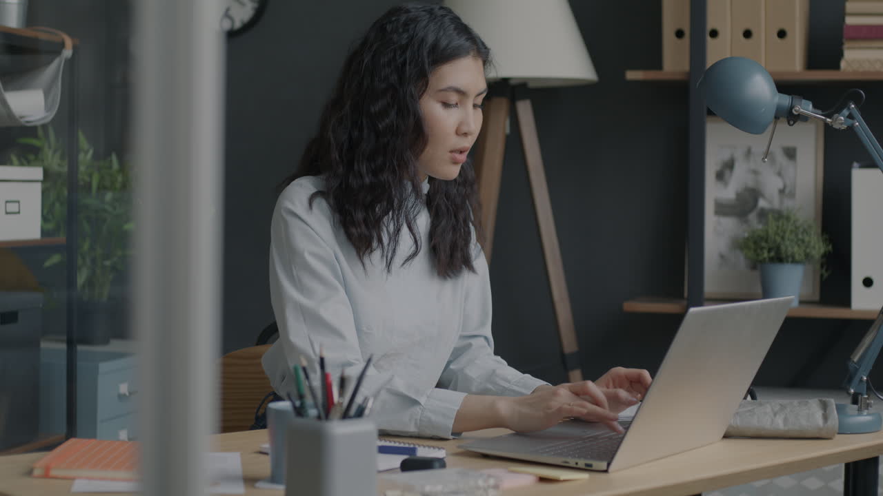 mujer trabajando en una computadora portátil en una oficina moderna