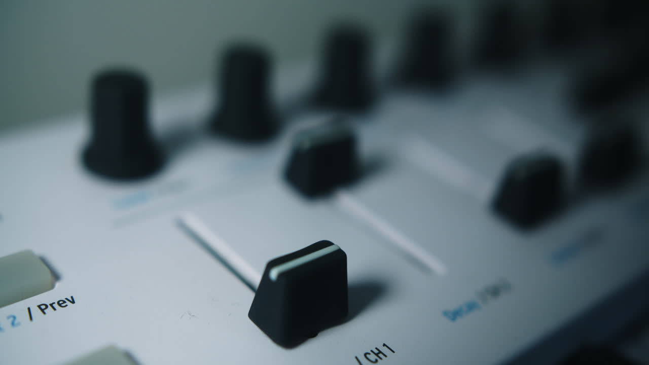 Amazing slow motion, close-up, spotlight lit shot of a young latin musician's hand raising the fade of a midi piano keyboard in his home studio in his darkened room.