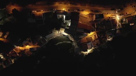 mesmerizing overhead view of a charming coastal fisherman village at night, adorned with beautiful street lights