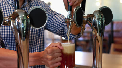 bar tender filling beer from beer pump 4k