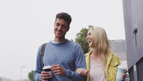 Front-view-of-Caucasian-couple-on-the-go-drinking-a-takeaway-coffee