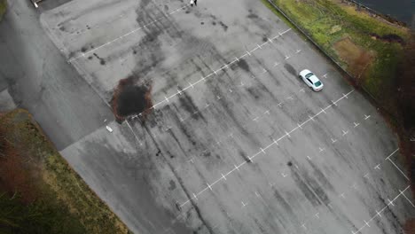 aerial footage of a car in an empty parkinglot drifting-1