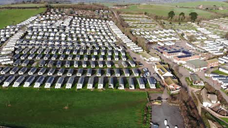 Imágenes-Aéreas-De-La-Pintoresca-Bahía-De-Ladram-Que-Muestra-Casas-Prefabricadas,-Disfrutando-De-La-Luz-Del-Sol