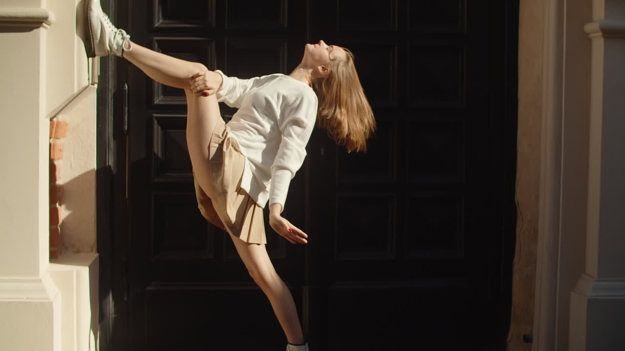 Woman Performing Dance Pose Outside Building