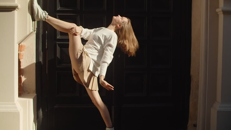Woman Performing Dance Pose Outside Building