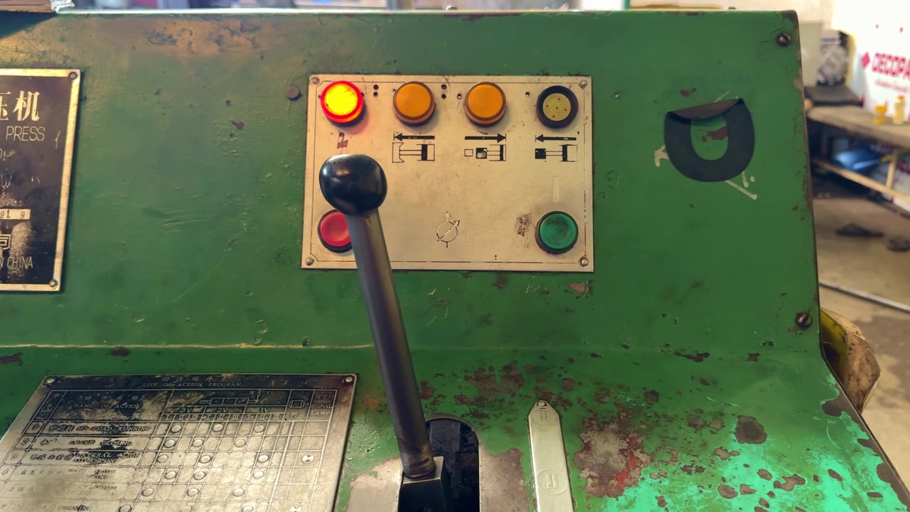Leva di controllo idraulica industriale su una macchina datata all'interno di una fabbrica. Vista dettagliata di attrezzature meccaniche utilizzate per processi di produzione e fabbricazione.