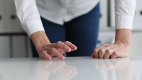 woman at table and drumming fingers on table