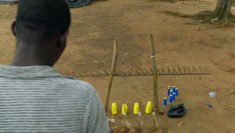 close up of african artisan rolling up blue kente textile yarn in an african village