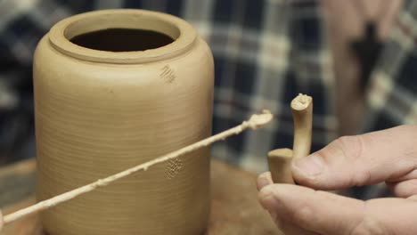 a potter makes a clay teapot with his own hands