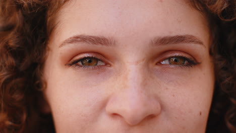 extreme closeup macro portrait of young face pretty womans eyes looking at camera smiling