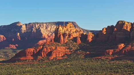 aerial ascending telephoto view of desert alpenglow on submarine rock, sedona arizona