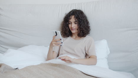 woman shopping online in bed