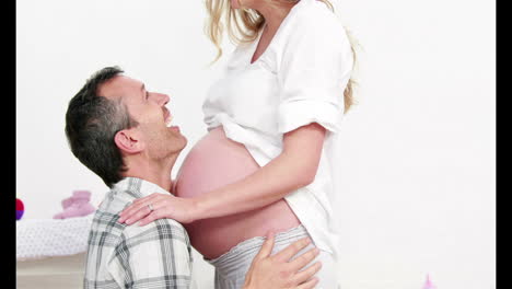 man kissing belly of his pregnant wife