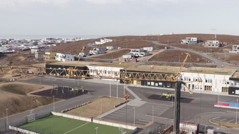 Aerial-of-construction-crane-not-working-on-grounds-of-Icelandic-school