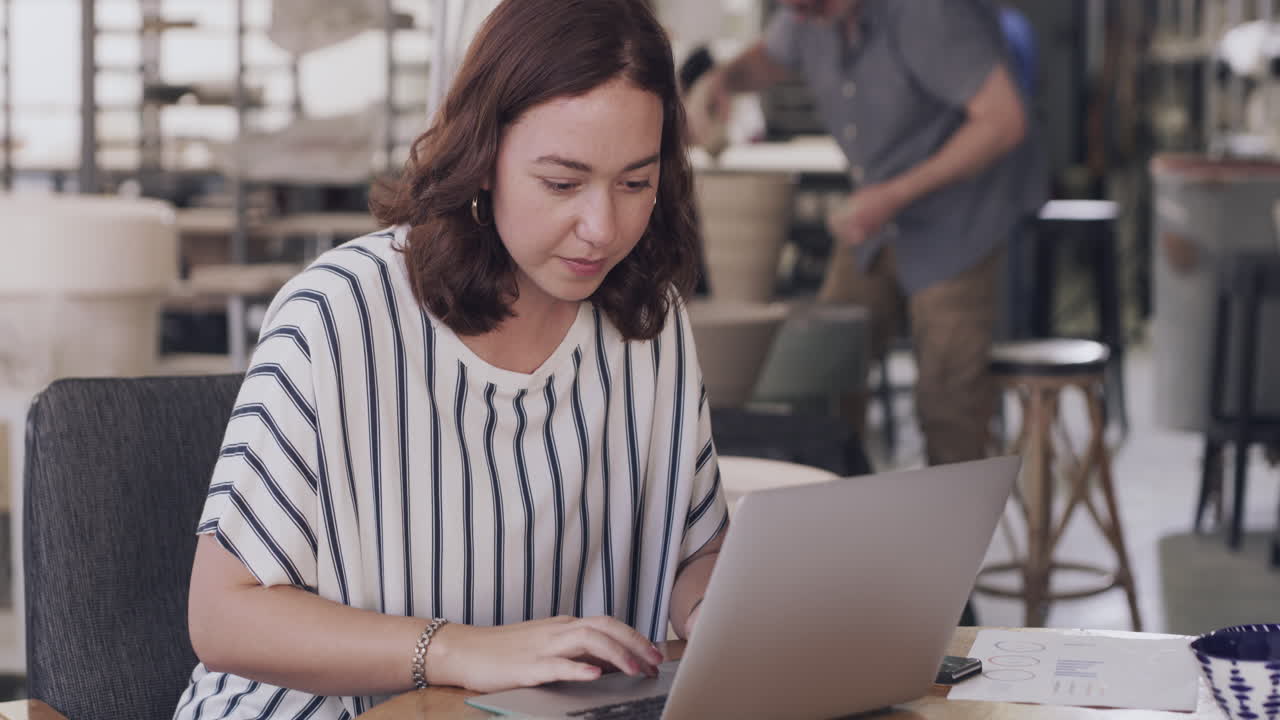 mujer trabajando en una computadora portátil en un estudio de cerámica