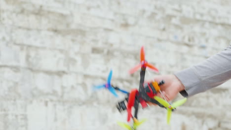 la mano lanza un pequeño dron de carreras, pasatiempos y entretenimiento.