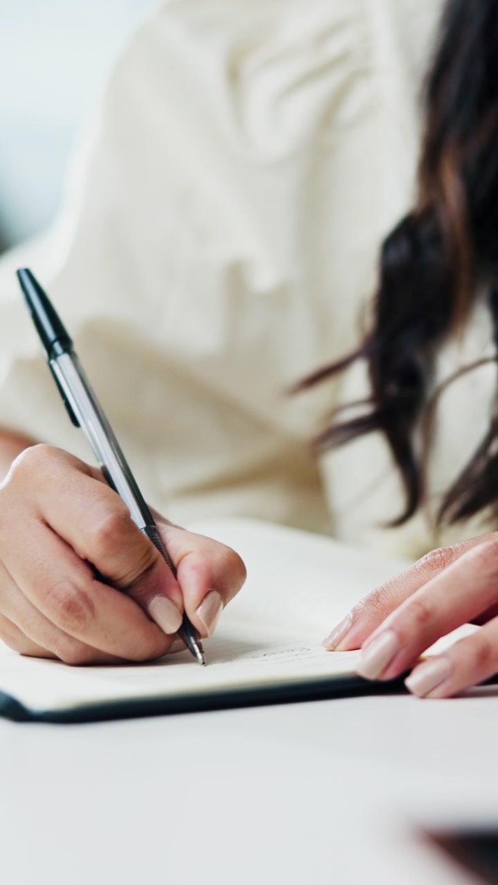 Woman Writing in a Notebook at a Desk