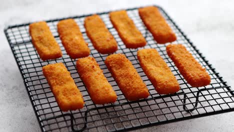filas de filetes de dedos de pescado fresco frito dorado