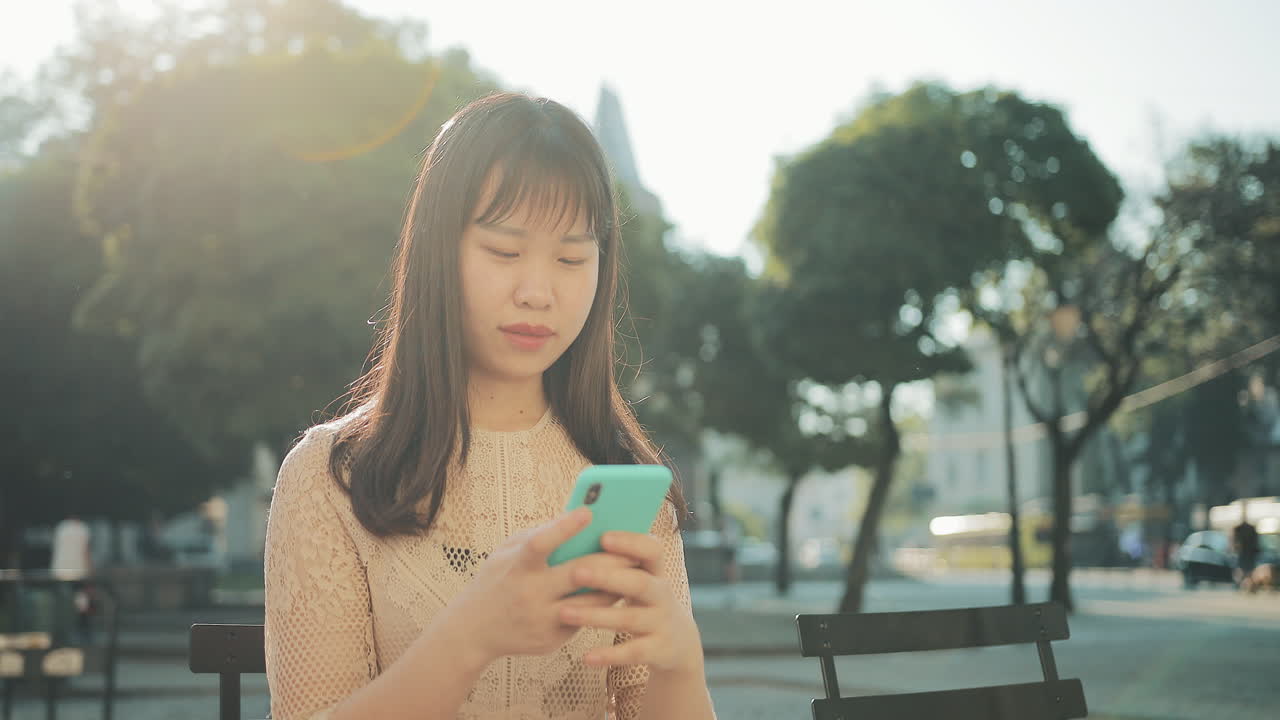 Asian woman using smartphone in a park