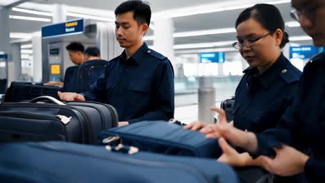 airport security personnel checking luggage