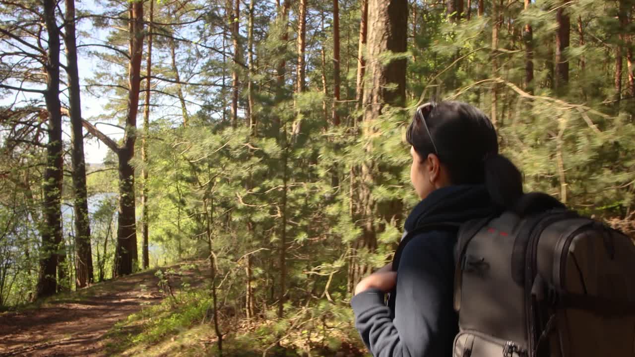 하이킹 여자 는 봄 의 녹색 숲 에서 하이킹 배 ⁇  을 들고  ⁇ 다